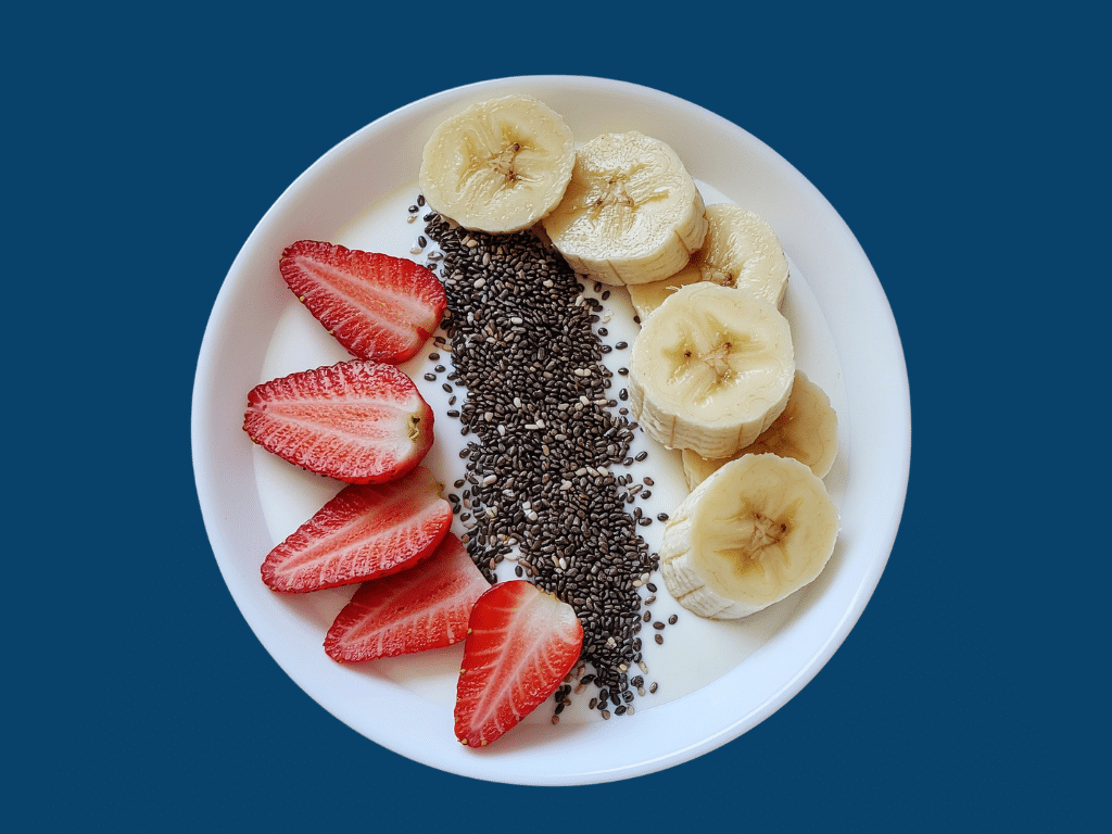 Image of a bowl of yogurt topped with bananas, strawberries, and chia seeds.